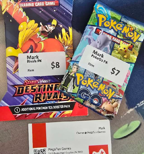Orbitect review photo showing Pokemon packs and MegaFun TCGs business card